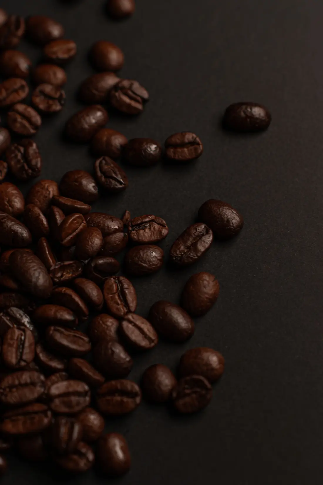 Granos de café tostados sobre fondo oscuro